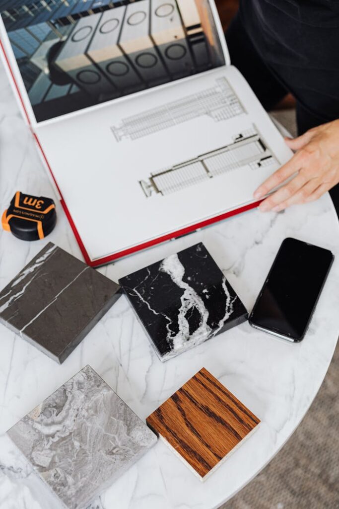 Overhead view of architectural designs with tile samples on a table.