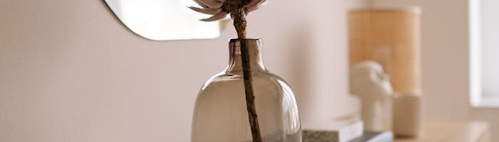 Stylish interior with dried flower in glass vase and modern accessories.
